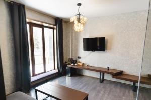 ein Wohnzimmer mit einem Tisch und einem Fernseher an der Wand in der Unterkunft Sofa Boutique Hotel & SPA in Sumy + 56 Fotos