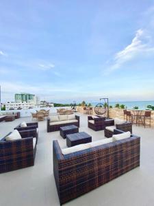 a group of chairs and couches on top of a building at Praiano Flat Tambaú in João Pessoa