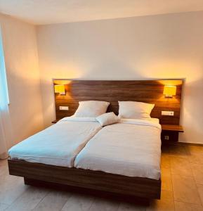 a bedroom with a large bed with two pillows at Hotel & Mühlenapartments by AVERA Gernsbach GmbH in Gernsbach