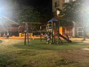 Eine Gruppe von Menschen sitzt nachts auf einem Spielplatz. in der Unterkunft entresierras in Valledupar