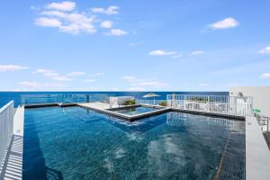 a swimming pool on top of a building with the ocean at Point West Premier Rentals in West Bay