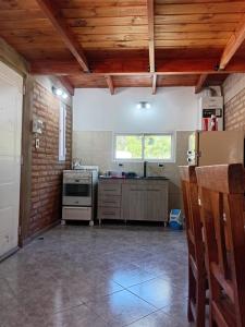 a large kitchen with a stove and a window at Angel Alpino Cabin in Cuesta Blanca