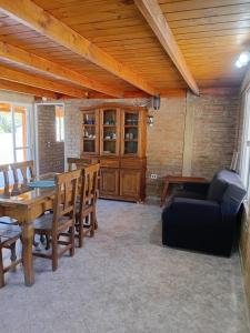 a dining room with a table and a couch at Angel Alpino Cabin in Cuesta Blanca