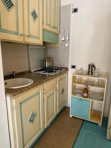 a small kitchen with a sink and a stove at Studio flat in Sardinia Costa Smeralda in Porto Rotondo