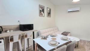 a dining room with a white table and chairs at Sous les Toits Yssoiriens - Centre-Ville in Issoire