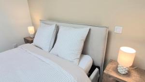 a bedroom with a bed with white sheets and pillows at Sous les Toits Yssoiriens - Centre-Ville in Issoire +5 photos