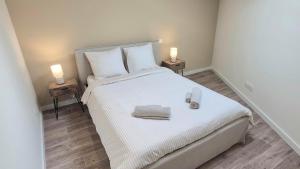 a bedroom with a white bed with two night stands at Sous les Toits Yssoiriens - Centre-Ville in Issoire