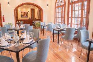 a dining room with tables and chairs and windows at Hotel Boutique Circasiana Palace in Quito