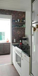 a kitchen with a white stove top oven next to a door at Victorian Summer House On Beautiful Natural Plot in Rønde