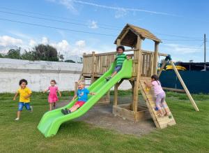 a group of children playing on a playground at The Beach Camping Village in Marina di Carrara