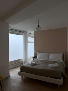 a bedroom with a bed and a large window at Rooms 78 in Castel di Sangro