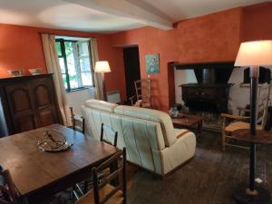 a living room with a couch and a table at Aile de la Maison de Chouliou in Balaguères