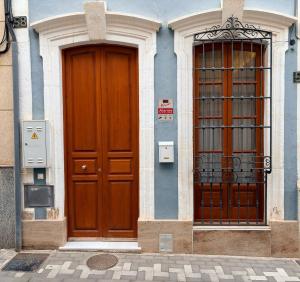 two large wooden doors on a building next to at LOFT La Palma in Almería