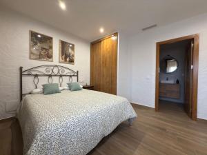 a bedroom with a large bed and a bathroom at Casa Rural Tomillo in Navalcán +21 photos