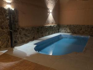 a large blue swimming pool in a room at Casa Rural Tomillo in Navalcán
