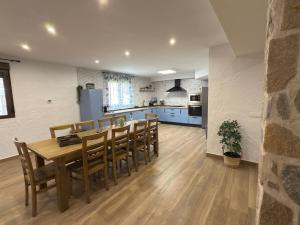a kitchen and dining room with a wooden table and chairs at Casa Rural Tomillo in Navalcán