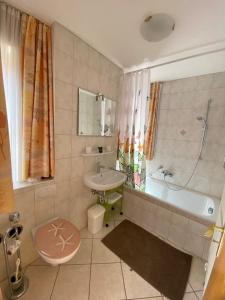 a bathroom with a tub and a sink and a toilet at Haus St_ Michael_ Ferienwohnung 1_4 in Schliersee