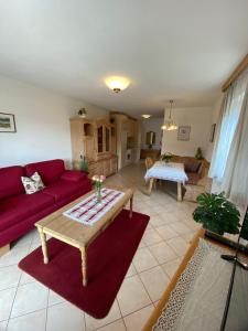 a living room with a red couch and a table at Haus St_ Michael_ Ferienwohnung 1_4 in Schliersee +58 photos