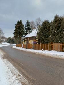 a house with a fence on the side of a road at Zacisze Sokolec in Ludwikowice Kłodzkie