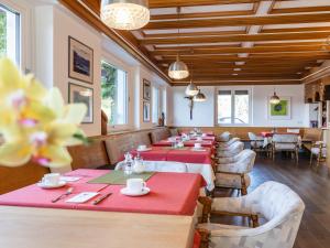 a restaurant with red tables and chairs and windows at B&B Chalet Andy in Schenna