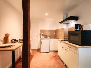 a large kitchen with white appliances and a table at L'écrin - Chablis - Homerepublique- Plein centre - Élégant - Parking à proximité in Chablis