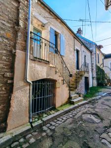 a brick building with a gate and stairs on a street at L'écrin - Chablis - Homerepublique- Plein centre - Élégant - Parking à proximité in Chablis