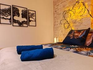 a bedroom with a bed with blue pillows on it at L'écrin - Chablis - Homerepublique- Plein centre - Élégant - Parking à proximité in Chablis +32 photos