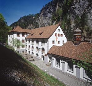 a large white building with a mountain in the background at Casa Casparis in Maienfeld