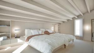 a large white bedroom with a large bed with white sheets at Ta Spitakia in Kos +66 photos
