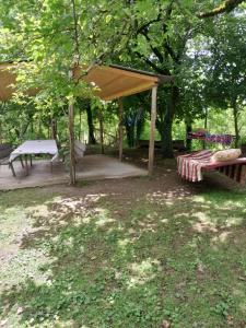 a picnic shelter with a bench and a picnic table at Riverside Cottage in Martvili