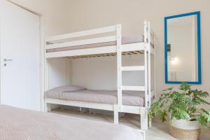a bedroom with two bunk beds and a mirror at Appartamento Tre Api by ElbaSummer in Procchio