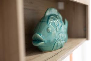 a blue bird vase sitting on a shelf at Appartamento Tre Api by ElbaSummer in Procchio +20 photos