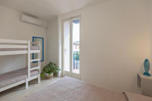 a bedroom with two bunk beds and a window at Appartamento Tre Api by ElbaSummer in Procchio