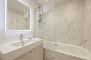 a white bathroom with a sink and a shower at Windsor Castle 4-Bed & Garden in Windsor
