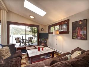a living room with a couch and a table at Hera's Cove - Oceanfront Oasis - Pet Friendly in Port Renfrew