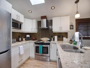 a kitchen with white cabinets and stainless steel appliances at Hera's Cove - Oceanfront Oasis - Pet Friendly in Port Renfrew