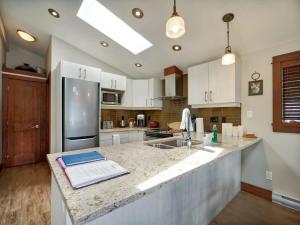 a kitchen with white cabinets and a counter top at Hera's Cove - Oceanfront Oasis - Pet Friendly in Port Renfrew