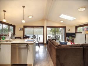 a kitchen and living room with a couch and a table at Hera's Cove - Oceanfront Oasis - Pet Friendly in Port Renfrew +25 photos