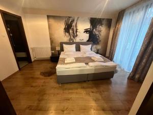 a bedroom with a bed and a painting on the wall at Hotel Brill Orosháza in Orosháza +28 photos