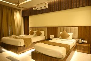 a hotel room with two beds in a room at Suthanthira stay Inn in Dindigul +51 photos