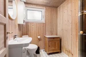 a bathroom with a white toilet and a sink at TV1706-Bindslev-Uglevej-7 in Tversted +13 photos