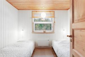 a bedroom with two beds and a window at TV1706-Bindslev-Uglevej-7 in Tversted