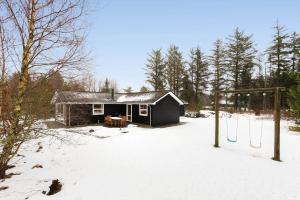 a small cabin in the snow with a swing at TV1706-Bindslev-Uglevej-7 in Tversted
