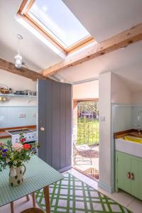 a kitchen with a table and a window at Cuckoo Bush Cottage - A unique cottage retreat in Holt