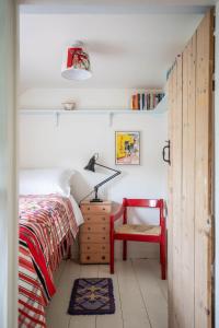 a bedroom with a bed and a desk and a chair at Cuckoo Bush Cottage - A unique cottage retreat in Holt