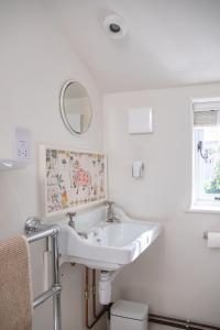 a white bathroom with a sink and a mirror at Cuckoo Bush Cottage - A unique cottage retreat in Holt +39 photos