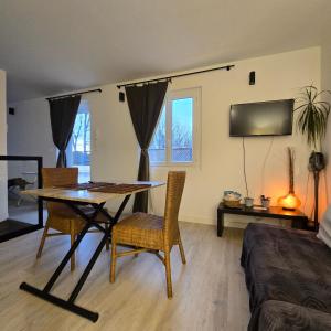 a living room with a table and chairs and a bed at Studio avec Terrasse in Arles