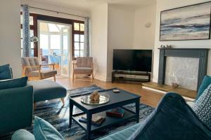 a living room with a couch and a tv at Crows Nest Dawlish in Dawlish