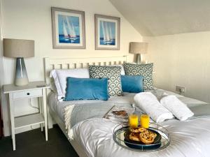 a bedroom with a bed with a tray of food on it at Crows Nest Dawlish in Dawlish