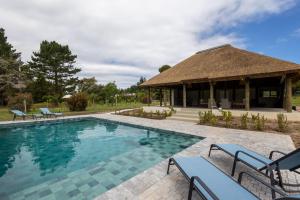 a resort pool with chairs and a pavilion at Five Elements Resort - Elephant Trailer Tiny House in Harkerville